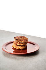 Single Golden Brown Chopped Chicken Cutlet or Patties with mozzarella cheese in red plate on concrete background.