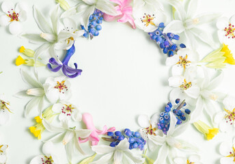 Flat lay frame from spring flowers on a white background. View from above, copy space. Springtime