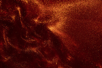 Abstract shiny glittering background. Magic Galaxy of golden dust particles in red fluid. Glittering particles of gold dust in a swirl of red liquid. - obrazy, fototapety, plakaty