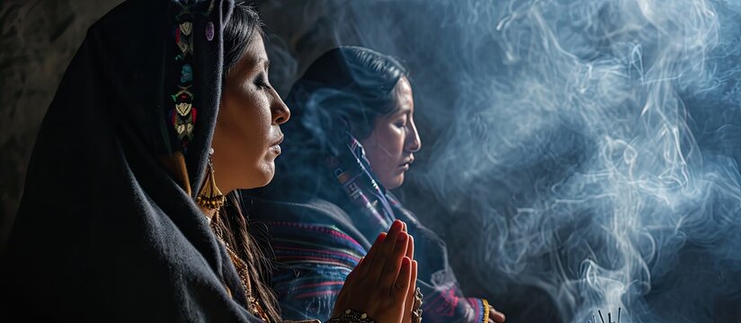 Mexican Latin woman with traditional clothes doing cleansing and spiritual meditations shaman with black shawl long hair pensive and concentrated among incense smoke together praying
