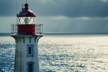 The silhouette of a weathered lighthouse stands against a backdrop of a glittering sea, symbolizing guidance and safety