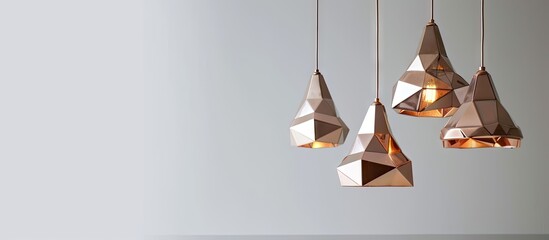Creative modern chandelier with geometric shaped lampshade and copper details hanging against white wall. Copy space image. Place for adding text