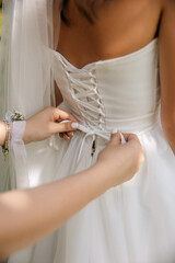 a friend of the bride is tying the dress, a close-up photo