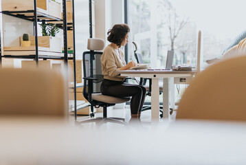 Middle-aged woman working on business expansion and discussing market analysis in a creative office.