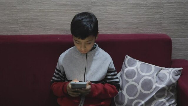 young kid watching mobile and playing online game at home caught by mother at night