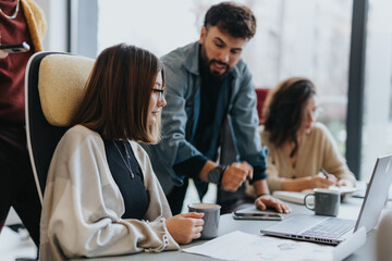 Multicultural employees collaborating on project development for company's profit growth in a creative office environment.
