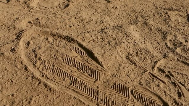 A close up shot of a shoe print on a sand ground. India.
