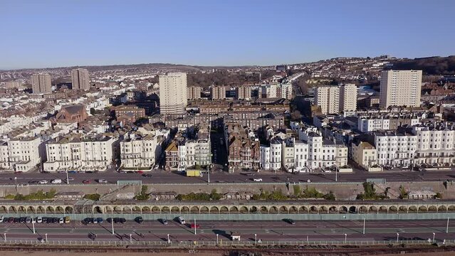 Aerial footage along Marine Drive on the seafront in Brighton, with Victorian buildings and the Volks Electric railway in view.