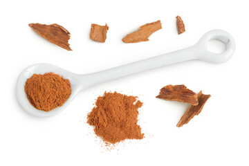 Cinnamon powder in ceramic spoon with cinnamon stick crushed isolated on white background. Top view. Flat lay.