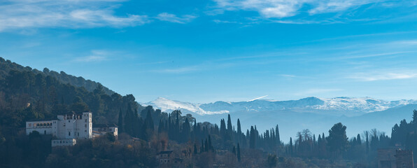 Panoramic view of the Generalife in the Alhambra (Granada, Spain) with the snow-capped peaks of the Sierra Nevada in the background