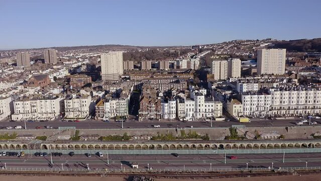 Aerial footage along Marine Drive on the seafront in Brighton, with Victorian buildings and the Volks Electric railway in view.