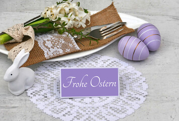 Frohe Ostern: Besteck mit Teller und Oster Dekoration auf einem Tisch 