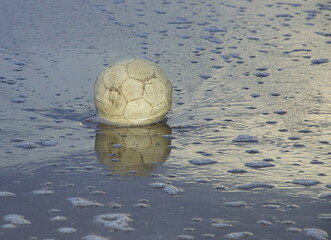 broken ball in the water on the beach