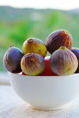 Bowl of ripe green and purple figs in summer