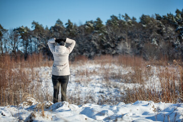 Młoda kobieta spacerująca zimą po górskim szlaku śnieżnym - obrazy, fototapety, plakaty