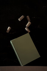 unlikely balance (corks, book, black background) - obrazy, fototapety, plakaty