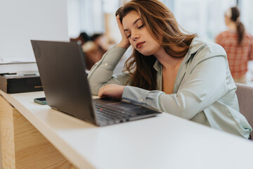 After a demanding day, the female employee falls asleep at her desk, seeking respite from the...