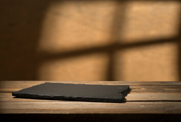 wood table green wall background with sunlight window create leaf shadow on wall with blur indoor...