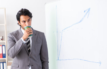 Young handsome businessman in front of whiteboard