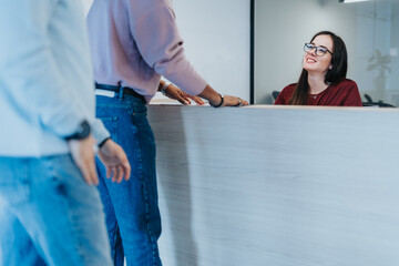 Businessmen in business attire negotiating a real estate deal. Papers are being signed and agreements are made. Real estate agent facilitates the sale.