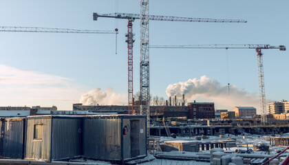 Construction site with cranes and work houses against blue sky, Saint-Petersburg, Russia, winter...