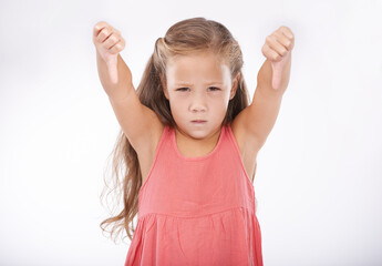 Thumbs down, girl or portrait of kid in studio for bad news, unhappy emoji sign and vote no on...