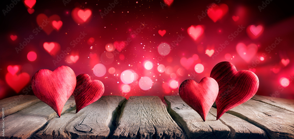 Wall mural valentines day - hearts on table in shiny abstract background with defocused lights
