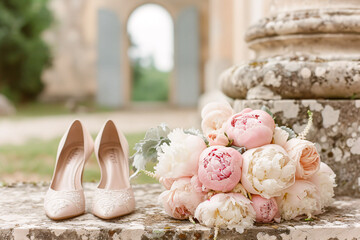 Fototapeta na wymiar Wedding composition flowers and shoes against the backdrop of the estate