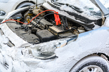 Charging automobile discharged battery by booster jumper cables at winter.  Problem starting a car...