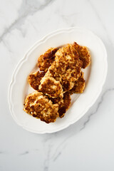  Golden Brown Chopped Chicken Cutlets or Patties with mozzarella cheese on white vintage plate.. Minimalistic food photo on white marble background 