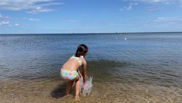 Little Girl Playing in Sea Water at the Beach