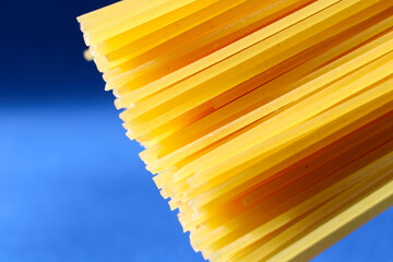 A bunch of Italian spaghetti peeking out from the top right corner of the photo on a beautiful blue...
