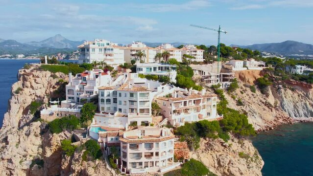 Drone footage of residential holiday apartments nested on rocky cliffs of Santa Ponsa, Calvia on Mallorca island. Expensive and luxury real estate in mediterranean.