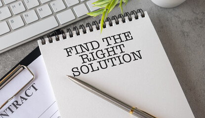 Find The Right Solution text on white notebook and pen on wooden background