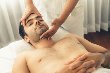 Caucasian man enjoying relaxing anti-stress head massage and pampering facial beauty skin...