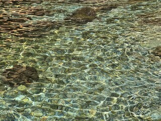 Pebbles and stones in the clear transparent sea water. 
