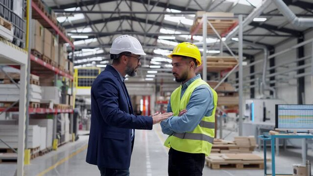 Supervisor, manager scolding employee in modern industry factory. Worker making mistake. Production manger is angry, dissatisfied for worker's poor quality work, safety viaolations.