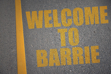 asphalt road with text welcome to Barrie near yellow line.
