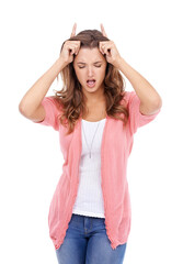 Woman, playful and devil horns in studio, bully and naughty gesture for attitude on white background. Female person, bad girl and fingers for emoji, bull and comedy or humor on isolated backdrop