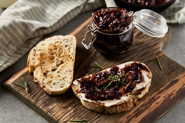 Delicious French Appetizer Freshly Cooked Onion Confit on toast with cream cheese and thyme. Wood...