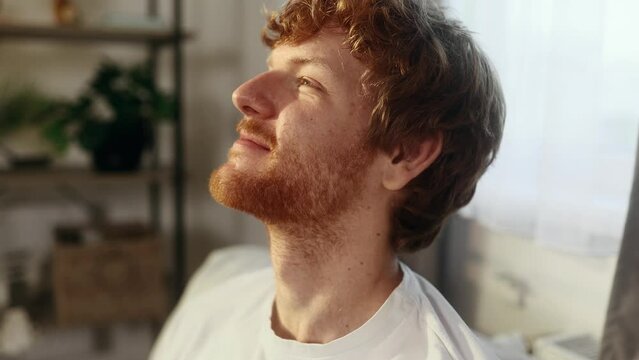 Close up portrait of smiling carefree red haired young man feeling absolutely happy and satisfied enjoying great day at home Self confidence guy looking ahead feel proud alone