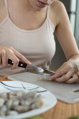 cutting shrimp on cutting board, preparing healthy and delicious food, cooking seafood, chef lifestyle at workplace, kitchen utensils