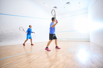 Sporty men joining squash competition showcasing skills on court