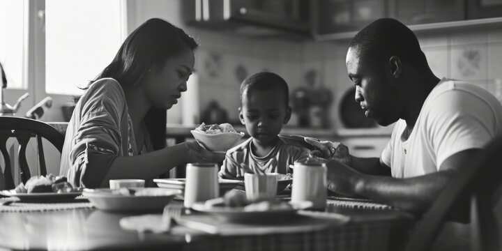 A black and white photo capturing a family enjoying a meal together. This versatile image can be used to depict family bonding, togetherness, and the joy of sharing a meal