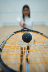 Closeup of squash racket in slim sporty woman hands