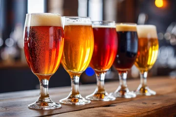 Foto op Canvas Glasses with different sorts of craft beer on wooden bar. Tap beer in pint glasses arranged in a row. Closeup of five glasses of different types of draught beer in a pub. © Hunman