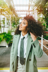Fototapeta premium Woman with tie and afro hair smiling while touching her hair.