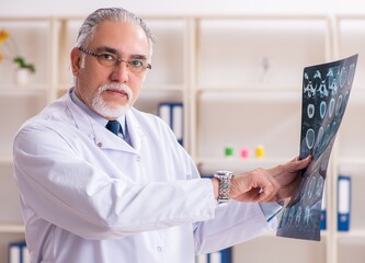 Aged male doctor radiologist in the clinic