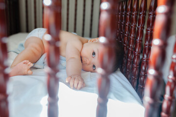 Baby laying in the crib looking at the camera