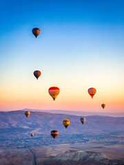 Aerial view of a fleet of hot air balloons, in Cappadocia, Turkey - 713573701